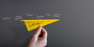 customer journey experience concept hand raise up paper plane against wall 300x150 1 1